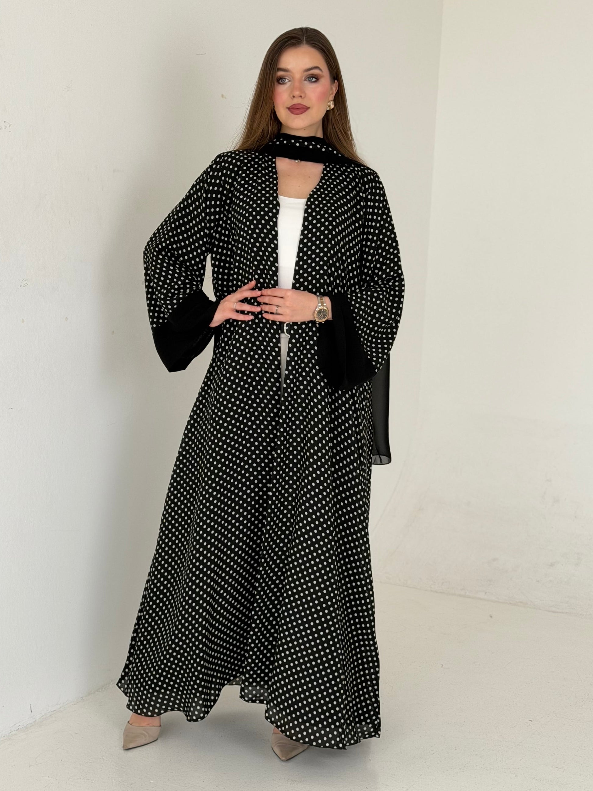 Woman wearing a black and white patterned outfit on a white background